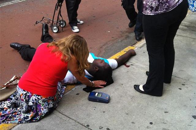 A person helps one of those shot in the gunfire